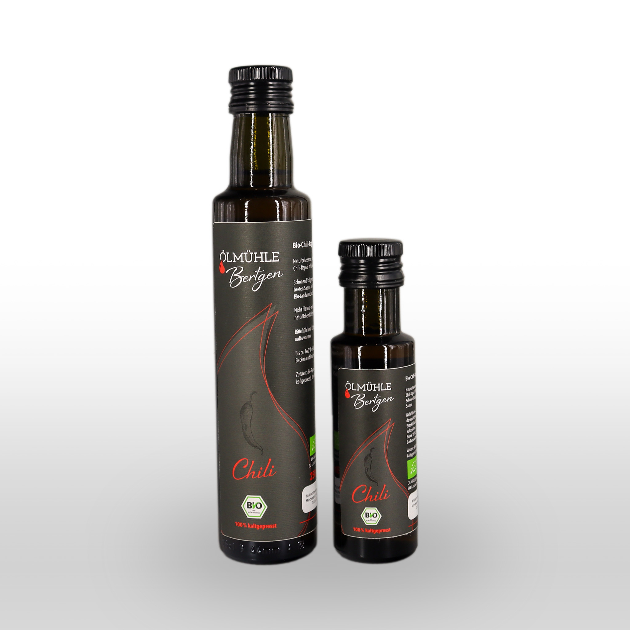 Zwei Flaschen Ölmühle Bertgen Chiliöl, eine große und eine kleine, mit schwarzem Etikett mit roter Chili-Darstellung und Bio-Zertifizierungssymbolen auf weißem Hintergrund.