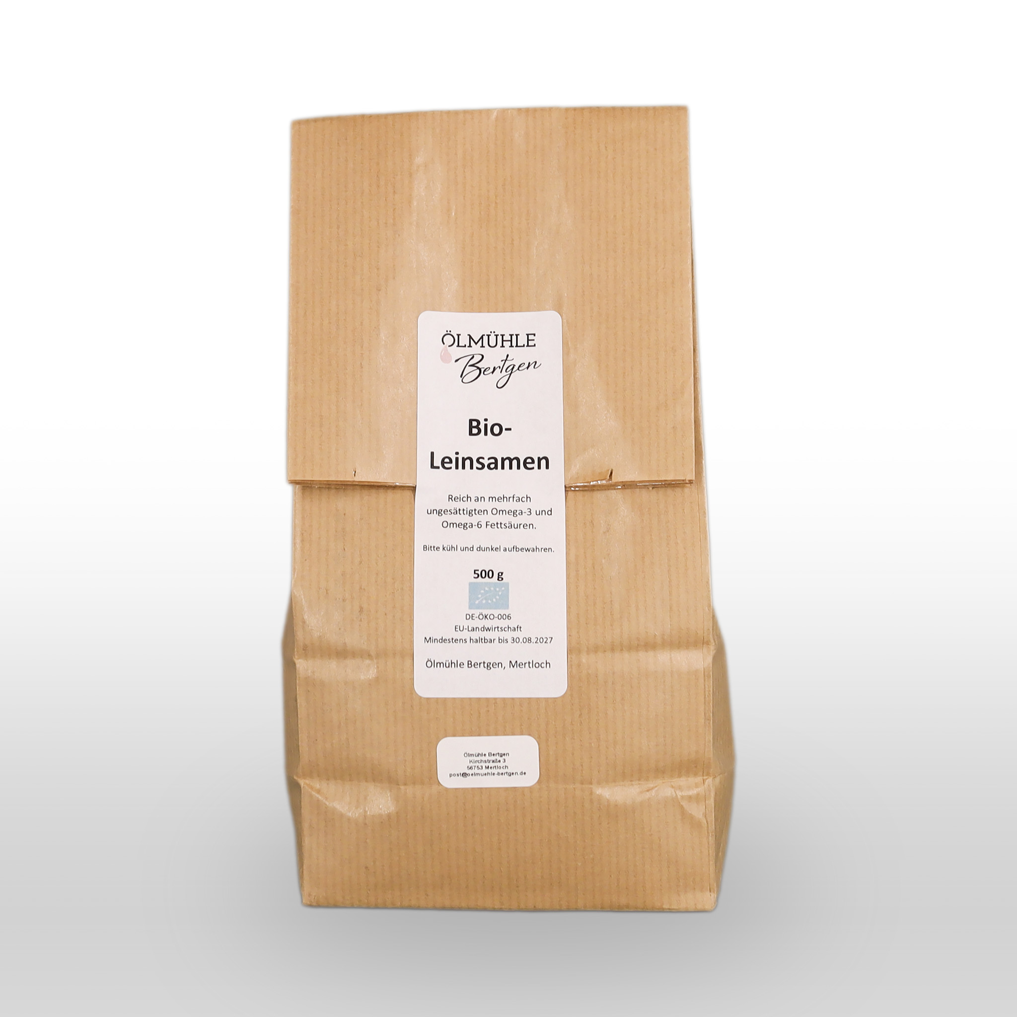 Eine braune Papiertüte mit der Aufschrift "Ölmühle Berzgen Bio-Leinsamen", die 500 g Bio-Leinsamen enthält, wird vor einem schlichten weißen Hintergrund gezeigt.